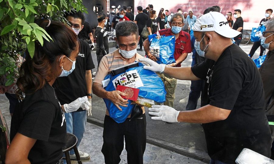 Comedian Harith Iskander (right) with his wife Dr Jezamine Lim (left) providing care bags to deserving recipients under their initiative, The Hope Branch, at Goddess of Mercy Temple in Jalan Masjid Kapitan Keling, George Town. ( February 20,2020 ). — ZHAFARAN NASIB/The Star
